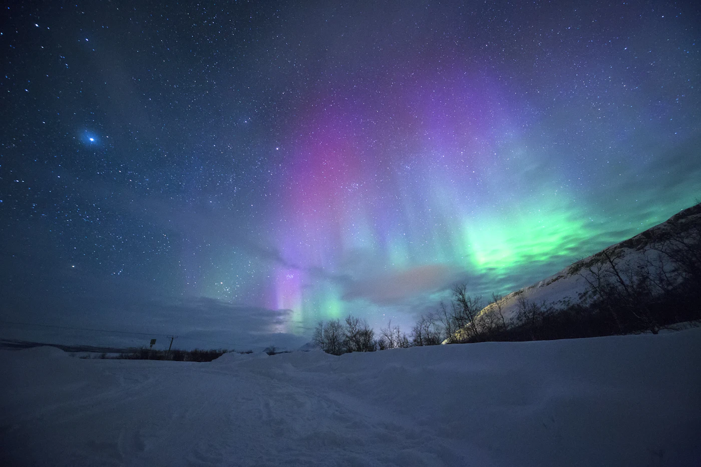 Aurora boreal verde sobre paisagem nevada